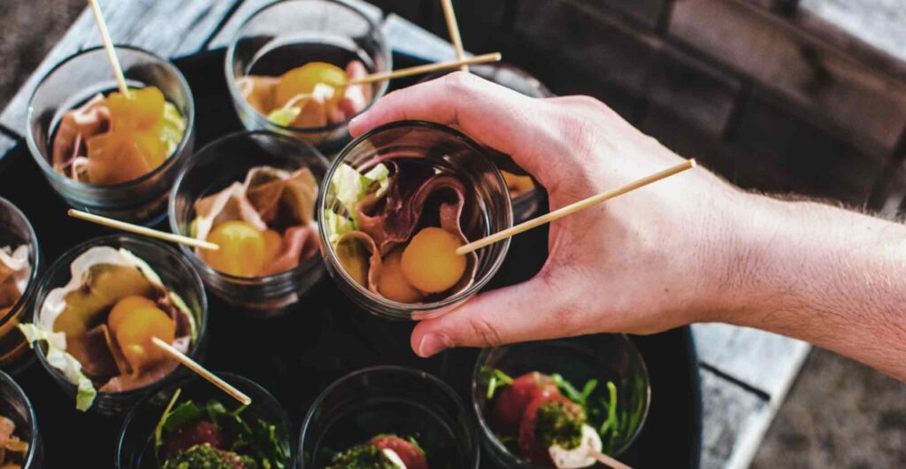 Mano de un hombre tomando un bocadillo de una mesa