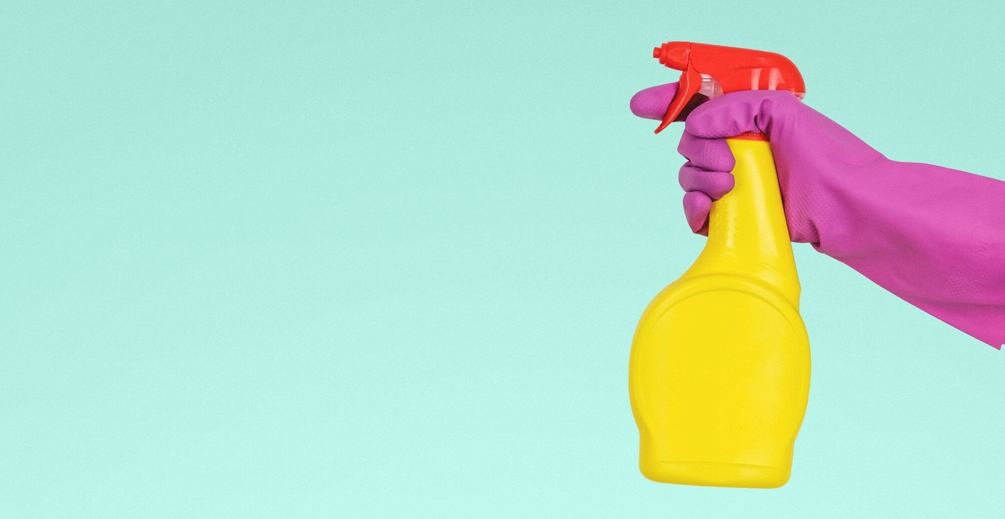 Mano con guante plastico sosteniendo un desinfectante