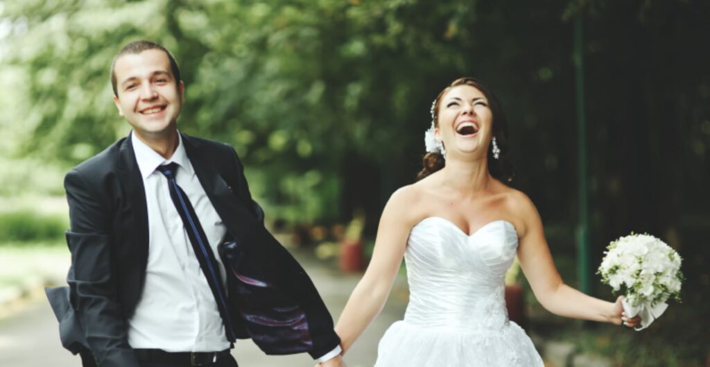 Novios tomados de la mano sonriendo