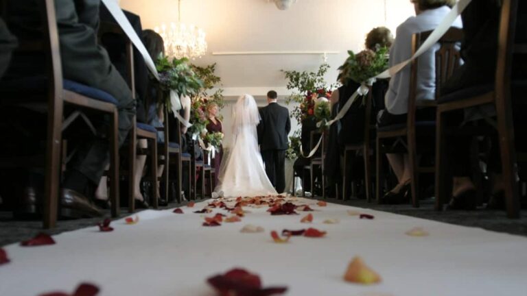 Novios caminando en pasillo de iglesia durante una boda
